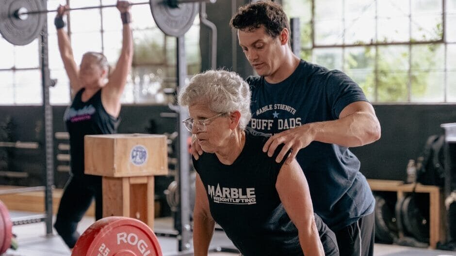coach assisting client during semi-private training at Marble Strength Freehold NJ